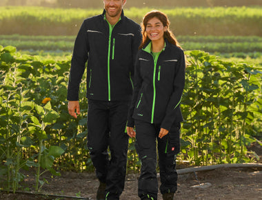 Mann und Frau in Arbeitskleidung im Sonnenblumenfeld